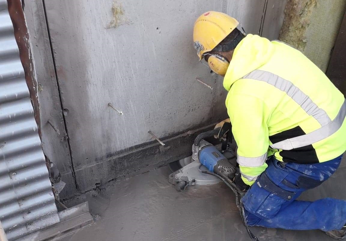 Operator z piłą diamentową tnący beton